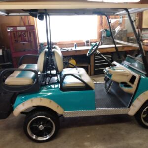 Customized golf cart with premium wheels and unique accessories in Flamingo Custom Carts shop.