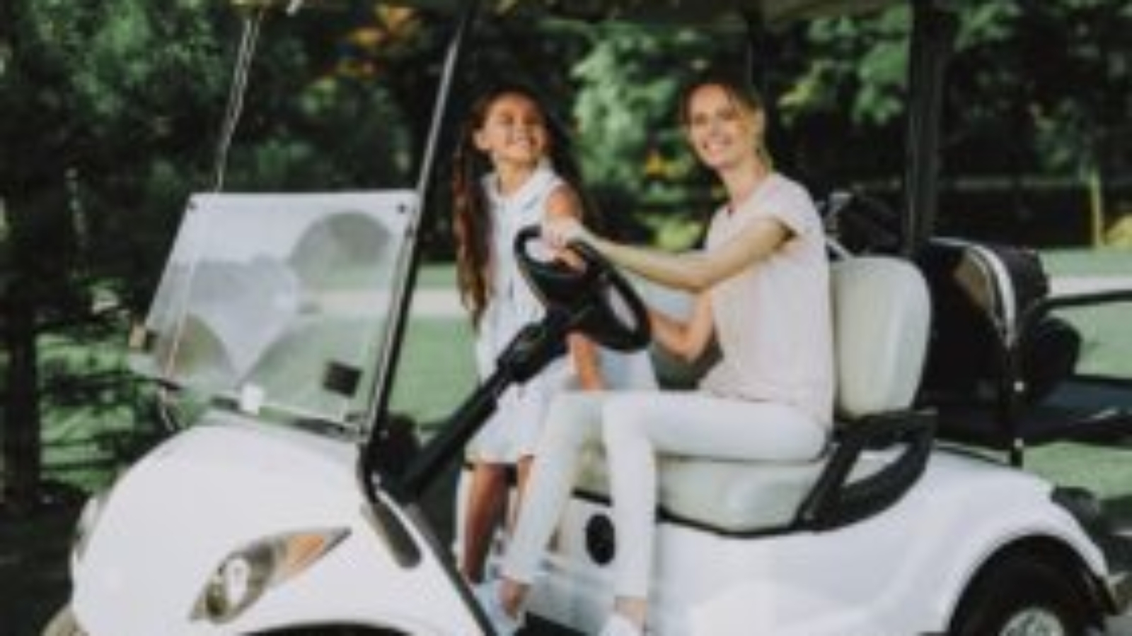 Woman and child riding in customized white golf cart