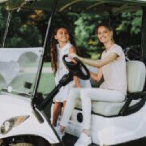 Woman and child riding in customized white golf cart