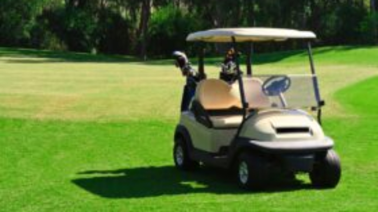 Golf cart on a green golf course, showcasing potential for lithium battery upgrades