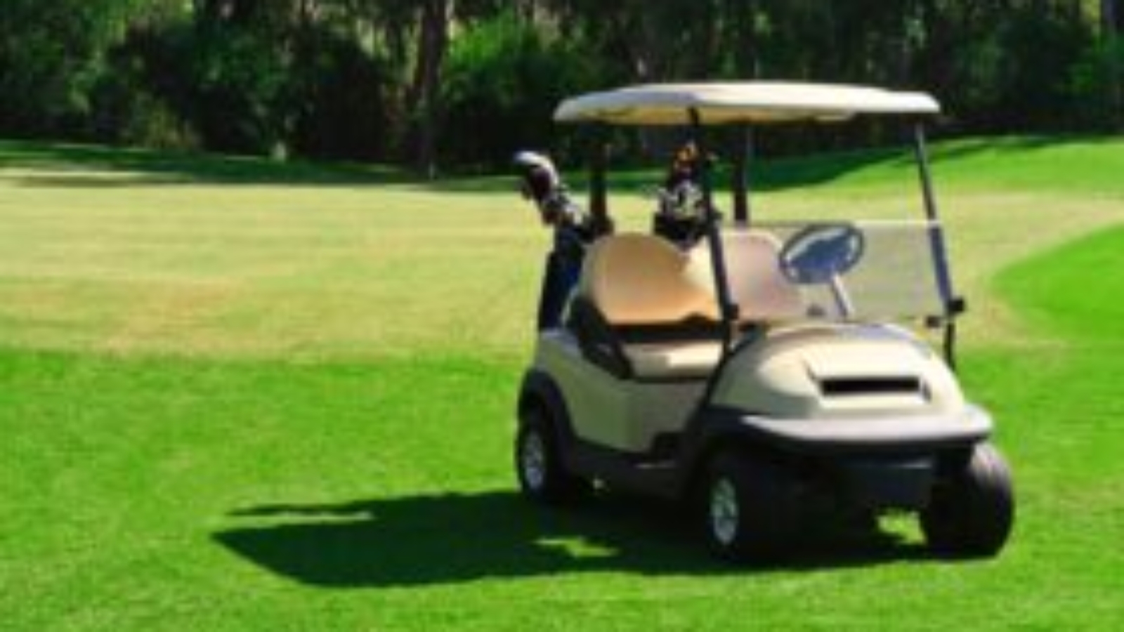 Golf cart on a green golf course, showcasing potential for lithium battery upgrades