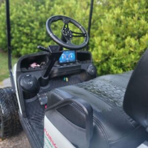 Custom golf cart steering wheel and dashboard with digital display and speakers.